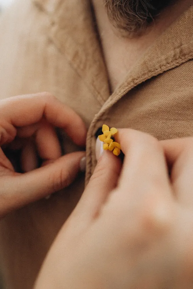 Zapichování knoflíkové kytičky do saka
